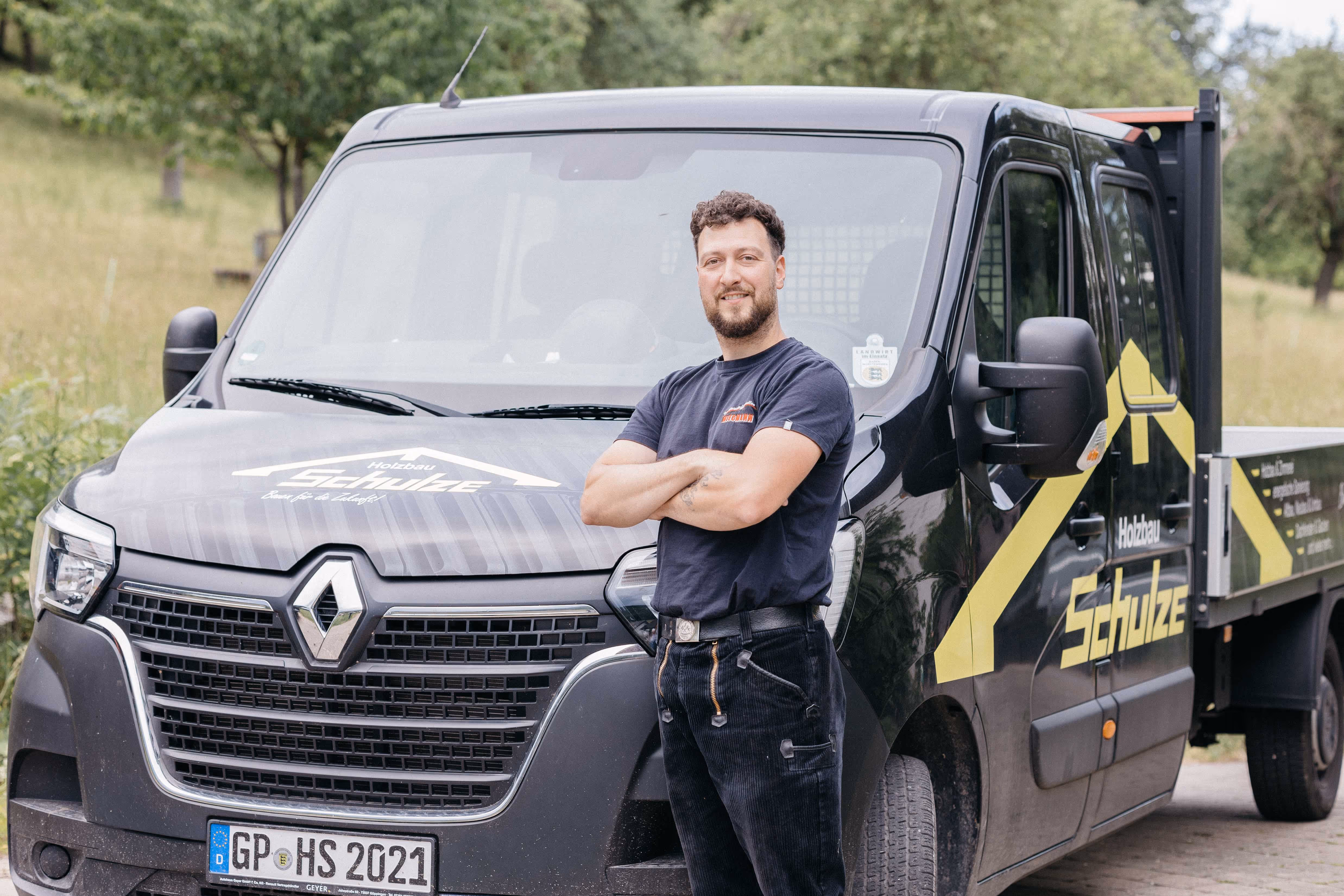 Lukas Schulze vor seinem Firmenfahrzeug von Holzbau Schulze